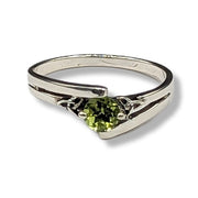 Silver ring with a green gemstone on a white background