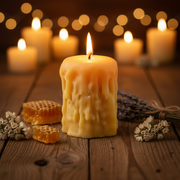 Candle with honeycomb and lavender on a wooden surface with blurred candles in the background