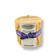Beeswax candle with a purple ribbon and Cheeky Bee label on a white background