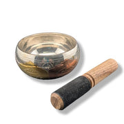 Singing bowl with wooden striker on a white background