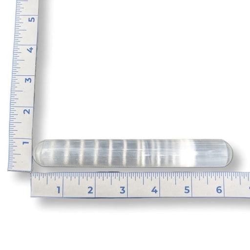 A selenite wand with measurement scale on a white background