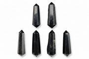 Six black crystal points of varying heights arranged on a plain white background.
