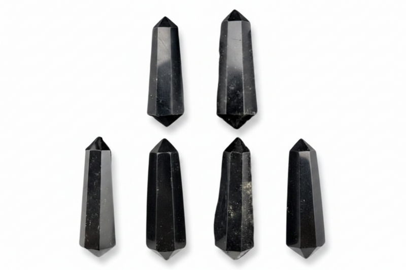 Six black crystal points of varying heights arranged on a plain white background.