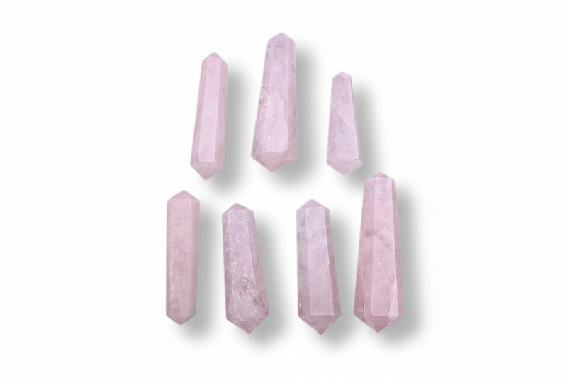 Seven pale pink crystal points arranged in two rows on a plain white background.