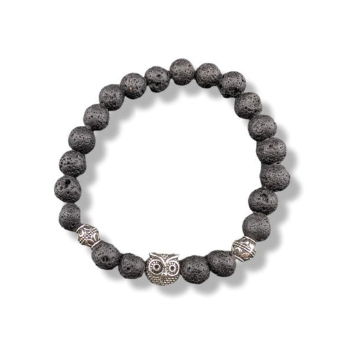 A beaded stretch bracelet made of dark gray porous lava stones, featuring a central silver owl charm and two textured silver spacer beads, shown on a white background.