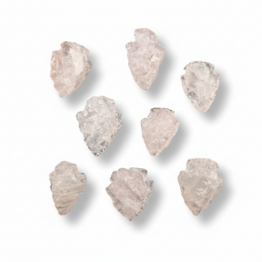 Seven raw, irregular pale pink quartz crystal arrowheads arranged on a clean white background with soft drop shadows.