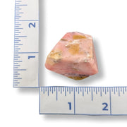 Pink stone with a ruler on a white background