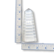 Selenite Obelisk next to a ruler on a white background