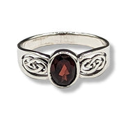 Silver ring with a red gemstone on a white background