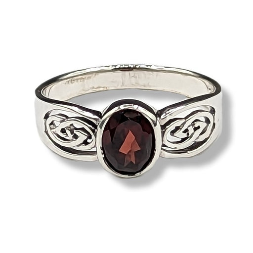 Silver ring with a red gemstone on a white background