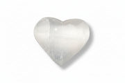 A polished heart-shaped selenite with a smooth, lustrous surface and subtle striations, shown on a plain white background with a soft drop shadow.