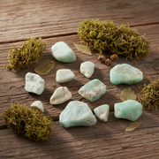 Green stones and moss on a wooden surface