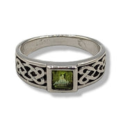 Silver ring with green gemstone and Celtic knot design on a white background