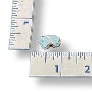 Larimar stone next to a ruler on a white background