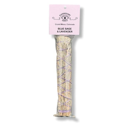 A packaged bundle of smudge sticks wrapped in lavender string, with a light pink header card reading  'BLUE SAGE & LAVENDER' on a white background.