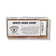 A wrapped bar of White Sage Soap from Fluorescent Ranch, showing the brown soap bar and a white label with black text on a white background.