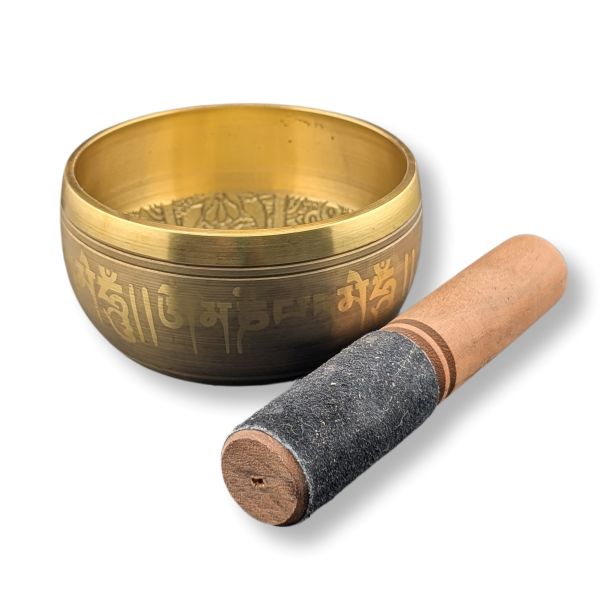 Brass singing bowl with engraved text and wooden mallet on a white background