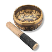 Decorative singing bowl with a wooden mallet on a white background