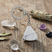 Marble keychain on a wooden surface with crystals and herbs