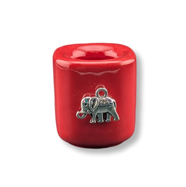 A glossy red mini candle holder with a small silver elephant pendant on the front, set against a plain white background.