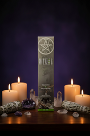 Product packaging for 'The Ritual' with candles and crystals on a dark background