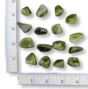 Green stones on a white background with rulers on both sides.
