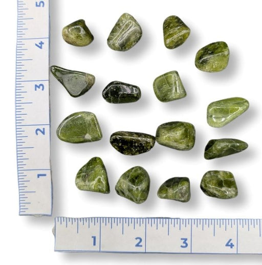 Green stones on a white background with rulers on both sides.