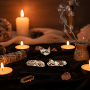 Crystal stones on a dark surface with candles and incense in the background