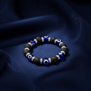 Bracelet with blue and black beads on a dark fabric background