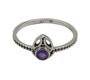 Silver ring with a purple gemstone on a white background