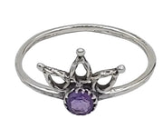 Silver ring with a purple gemstone on a white  background