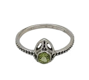 Silver ring with a green gemstone on a white background