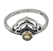 Silver ring with a yellow gemstone on a white  background