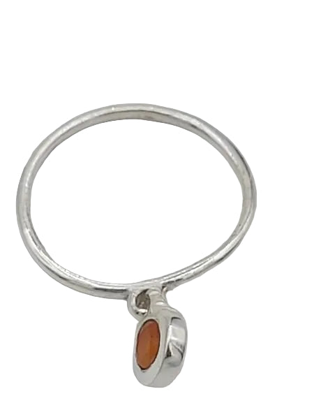 Silver ring with a small orange stone on a white background