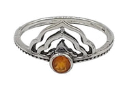 Silver ring with a central orange stone on a white background