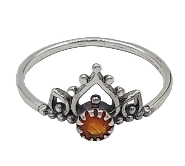 Silver ring with a central orange stone on a white background.