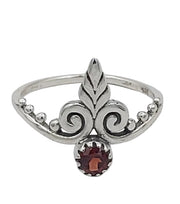 Silver ring with a garnet stone on a white background