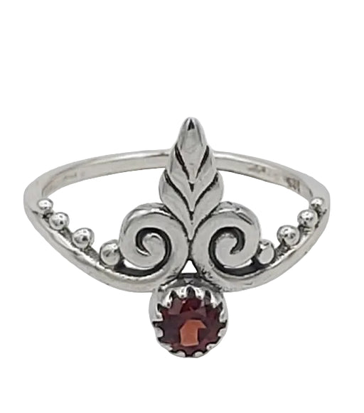 Silver ring with a garnet stone on a white background