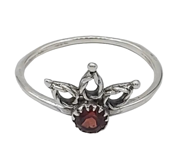 Silver ring with a red gemstone on a white background