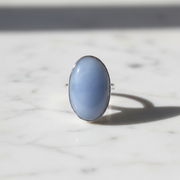 Blue ring with a silver band on a marble surface