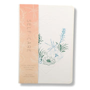 Journal with floral design and 'Self-Care' text on a white background