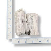 Mineral sample next to a ruler on a white background