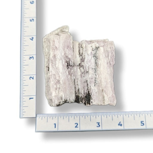Mineral sample next to a ruler on a white background