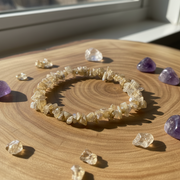 Crystal bracelet on a wooden surface with scattered crystals