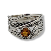 a wavy sterling silver ring with citrine on a white background