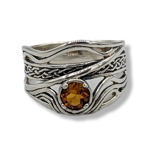 a wavy sterling silver ring with citrine on a white background