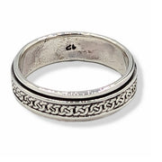 Silver ring with intricate design on a white background
