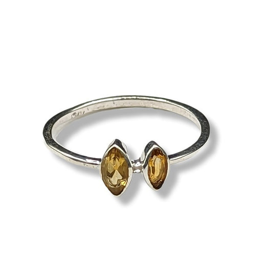 Silver ring with two yellow gemstones on a white background