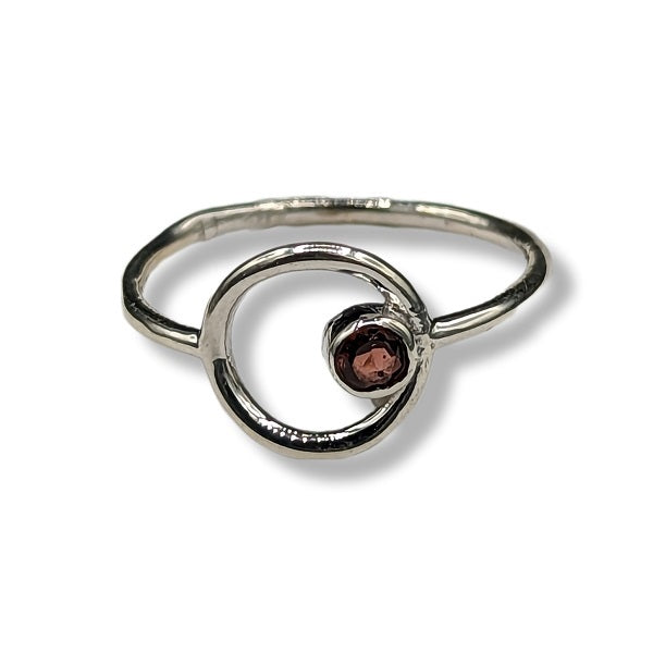 Silver ring with a central gemstone on a white background