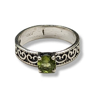 Silver ring with green gemstone on a white background